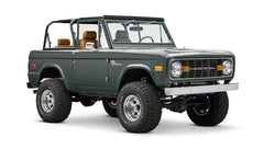 Classic Ford Bronco dark green front right angled view on white background with open top.