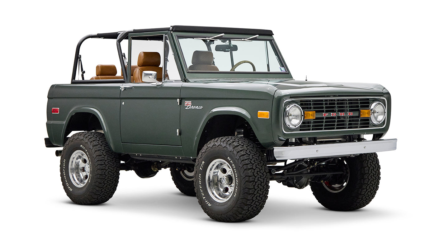 Classic Ford Bronco dark green front right angled view on white background with open top.