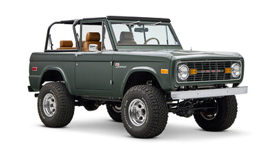 Classic Ford Bronco dark green front right angled view on white background with open top.