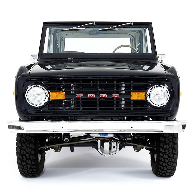 Front view of a black Classic Ford Bronco with windshield folded down on white background