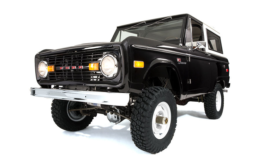 Black Classic Ford Bronco lifted on off-road tires with white wheels and white roof