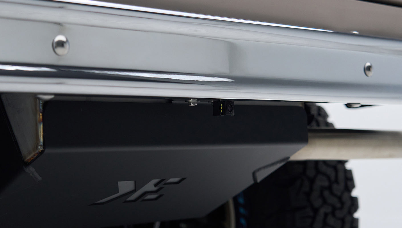 Rear bumper underside showing small black camera mounted near trailer hitch