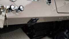 Dashboard underside with mounted black device near passenger footwell