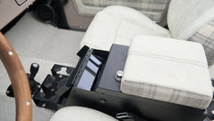 Center console area inside Classic Ford Bronco with armrest and storage compartment