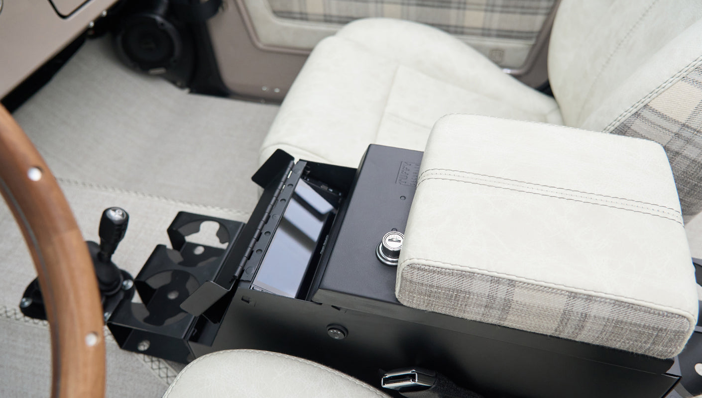 Center console area inside Classic Ford Bronco with armrest and storage compartment