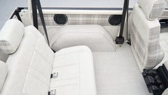 Rear seating area of Classic Ford Bronco with light upholstery and built-in speakers
