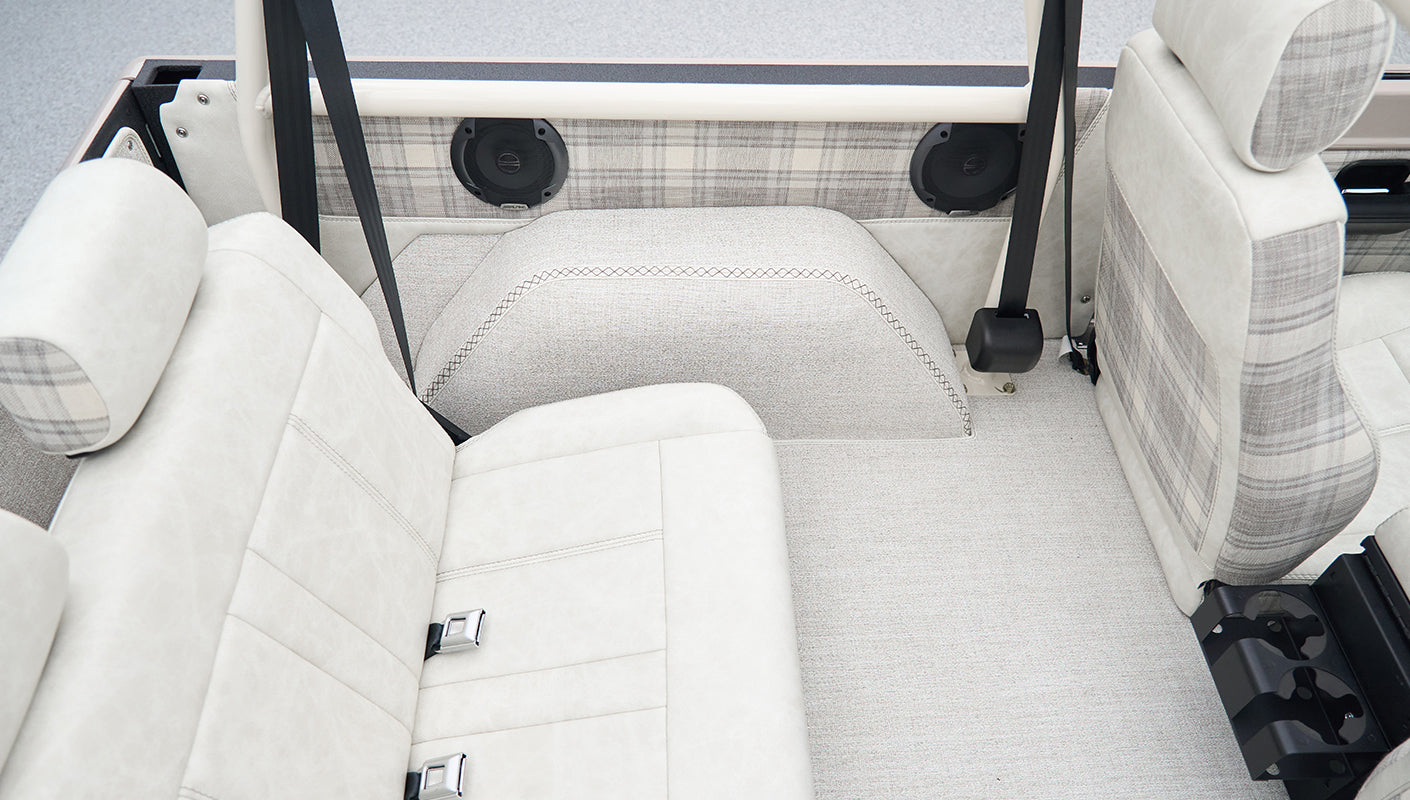 Rear seating area of Classic Ford Bronco with light upholstery and built-in speakers