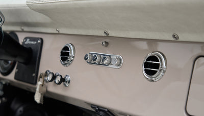 Dashboard of Classic Ford Bronco with round air vents and chrome climate control knobs