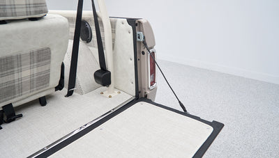 Rear cargo area of Classic Ford Bronco with open tailgate and light upholstery