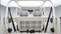 Rear view of Classic Ford Bronco interior with white and plaid seats and roll cage