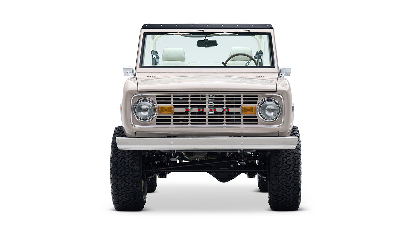 Front view of a Classic Ford Bronco in dove gray with beige interior and black roof