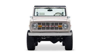 Front view of a Classic Ford Bronco in dove gray with beige interior and black roof