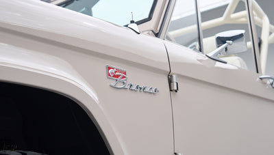 Side close-up of Classic Ford Bronco badge on the front fender in dove gray