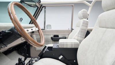 Interior view of Classic Ford Bronco showing steering wheel and plaid fabric seats