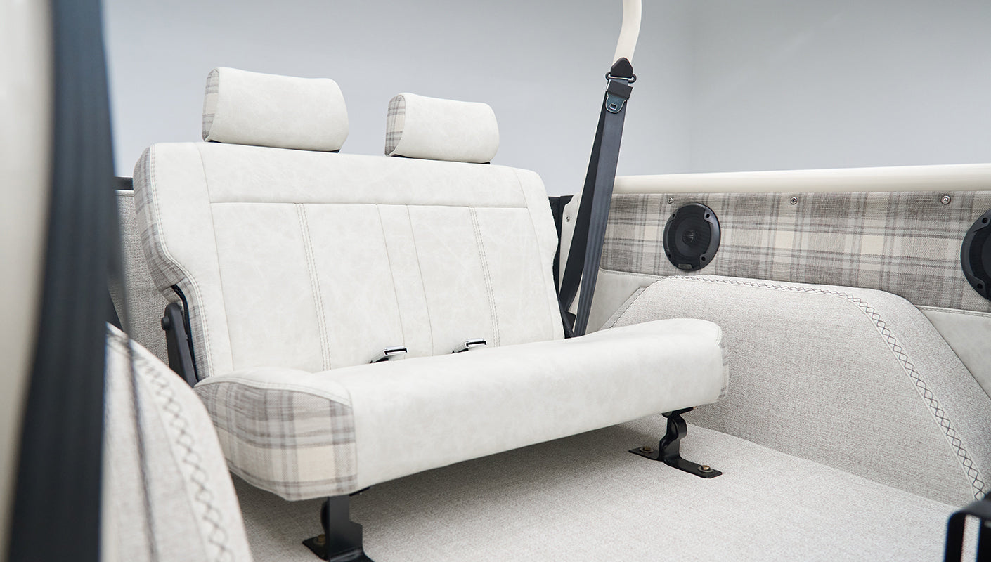 White and gray plaid rear seat and side panel with speaker in classic Ford Bronco interior