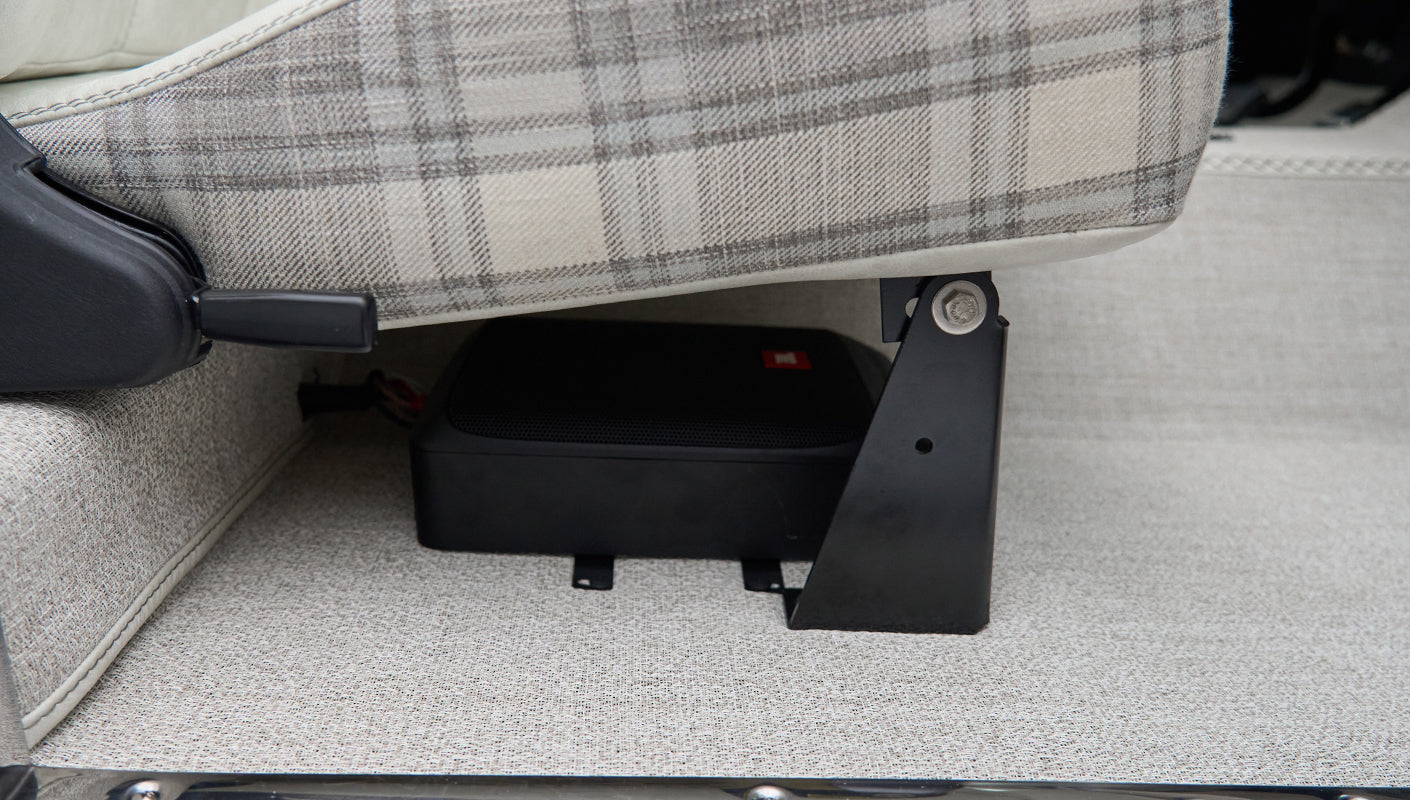 Close-up underside of a seat showing black mounted speaker in Classic Ford Bronco interior