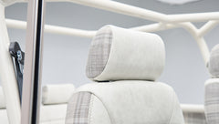 Headrest detail featuring white leather and plaid fabric upholstery in Classic Ford Bronco interior