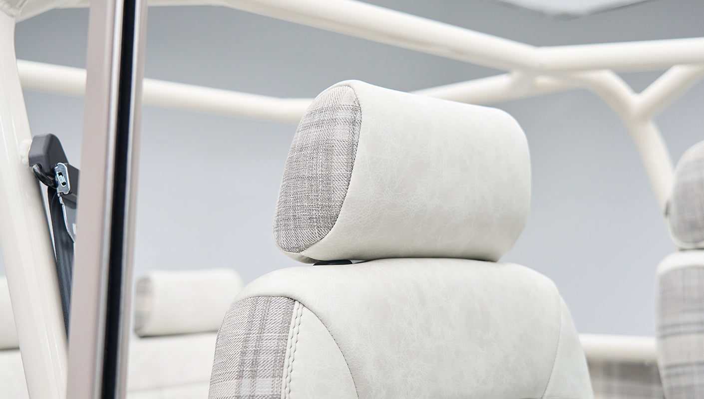 Headrest detail featuring white leather and plaid fabric upholstery in Classic Ford Bronco interior