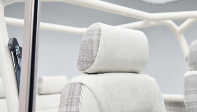 Headrest detail featuring white leather and plaid fabric upholstery in Classic Ford Bronco interior