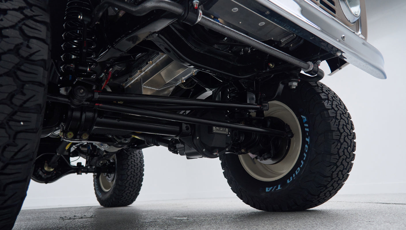 Front suspension and differential components visible under lifted Classic Ford Bronco