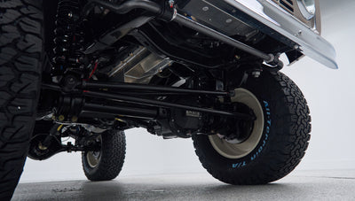 Front suspension and differential components visible under lifted Classic Ford Bronco