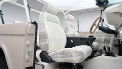 Close-up side view of front seat in Classic Ford Bronco with plaid fabric and seat belt