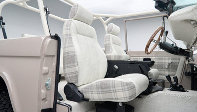 Close-up side view of front seat in Classic Ford Bronco with plaid fabric and seat belt