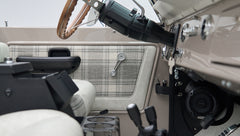 Classic Ford Bronco door interior panel with plaid fabric and manual window crank