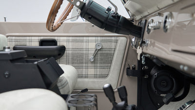 Classic Ford Bronco door interior panel with plaid fabric and manual window crank