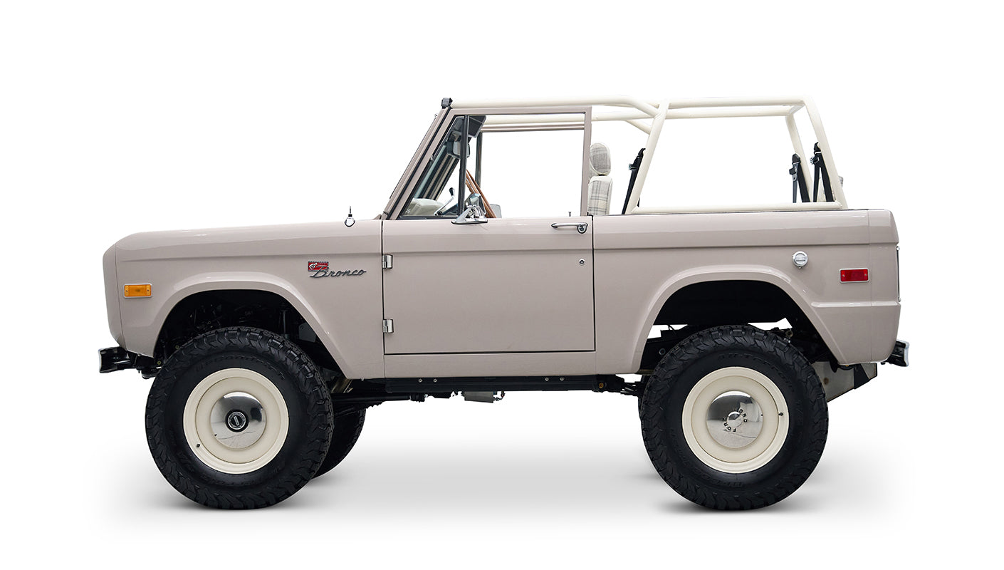 Side view of Classic Ford Bronco in dove gray with white wheels and off-road tires