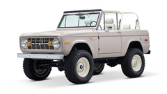 Classic Ford Bronco in dove gray, white steel wheels, front passenger side angle view