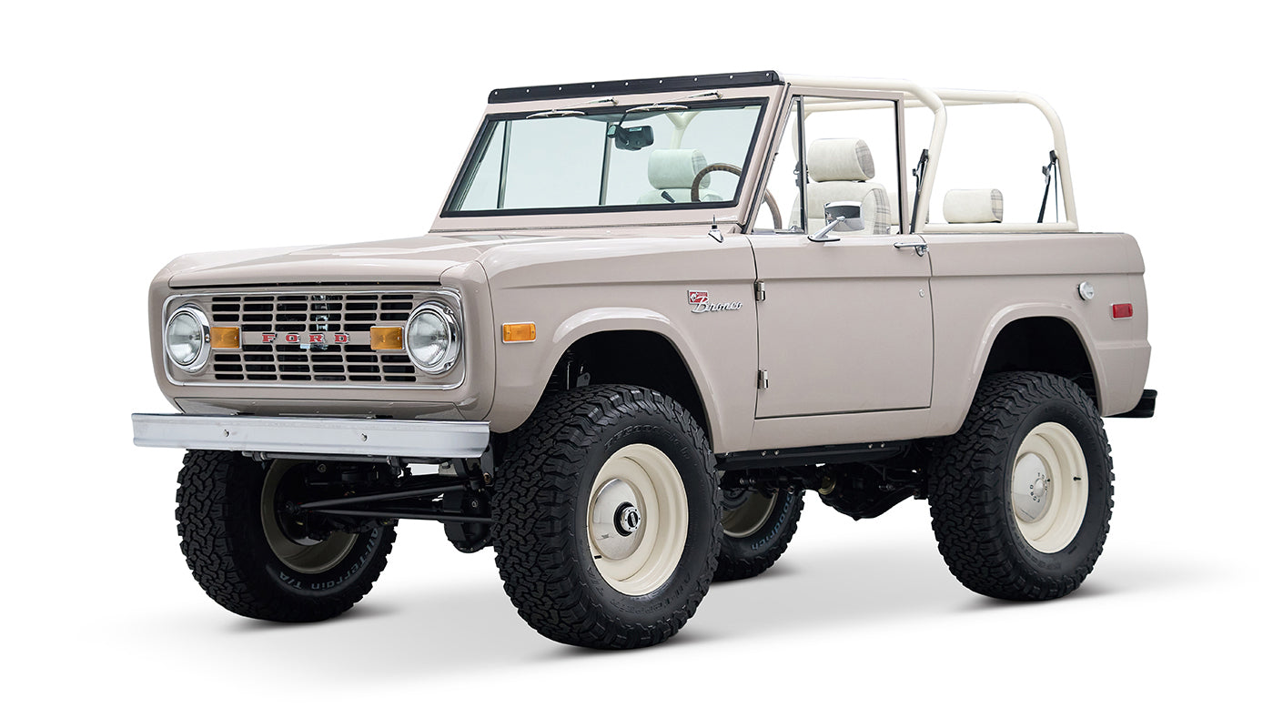 Classic Ford Bronco in dove gray, white steel wheels, front passenger side angle view