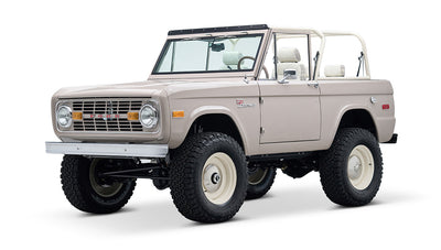 Classic Ford Bronco in dove gray, white steel wheels, front passenger side angle view