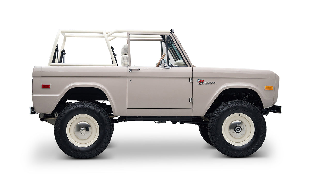 Classic Ford Bronco in dove gray with white wheels, side profile