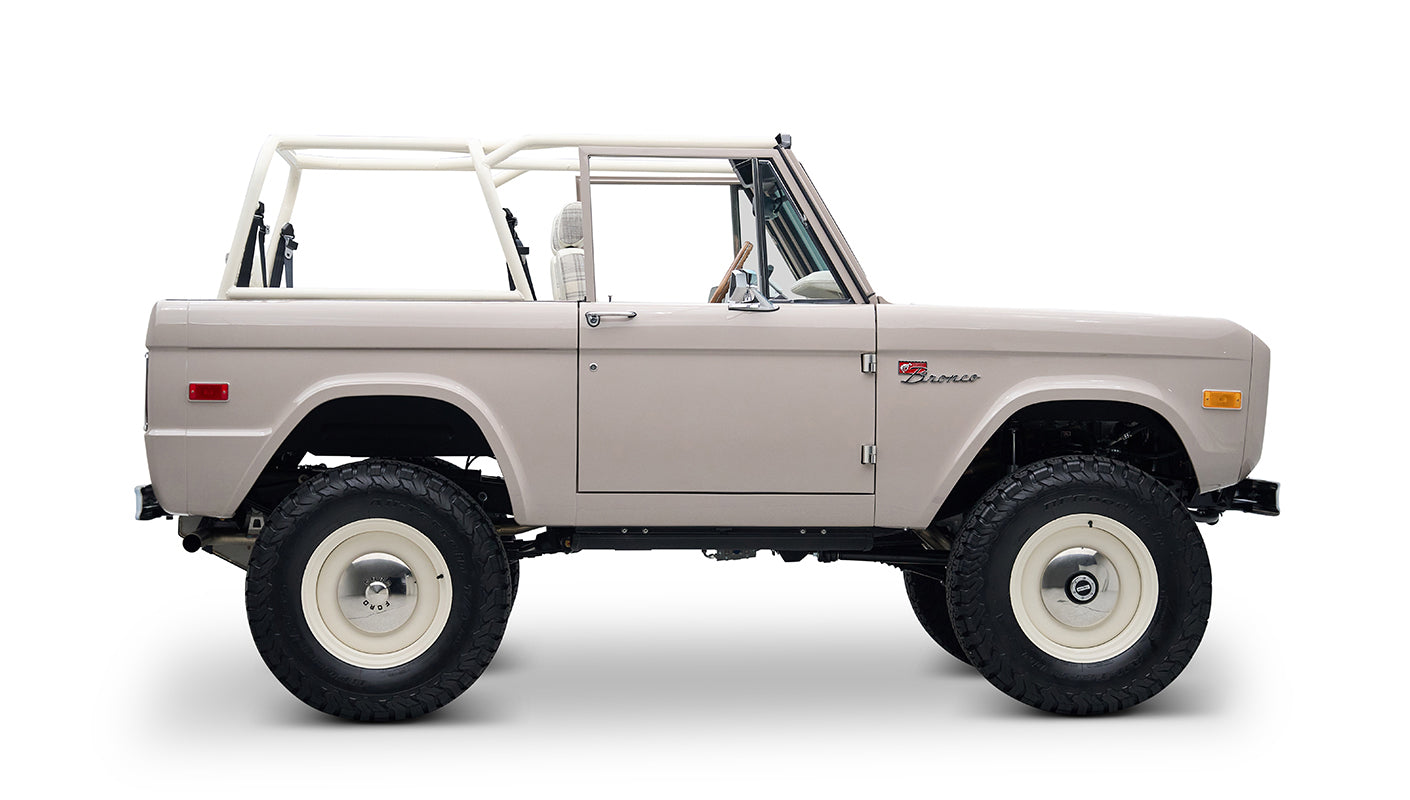 Classic Ford Bronco in dove gray with white wheels, side profile