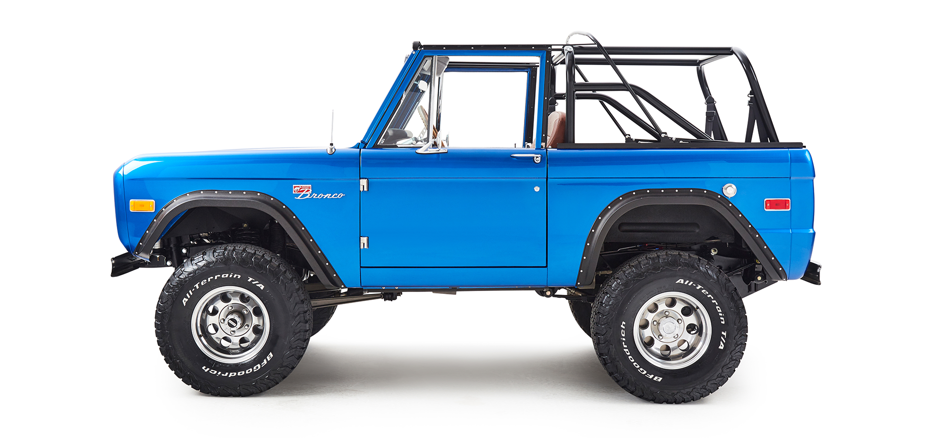 Side profile of blue Classic Ford Bronco with roll cage and large off-road tires