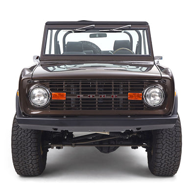 Front view of a brown Classic Ford Bronco with windshield and black interior