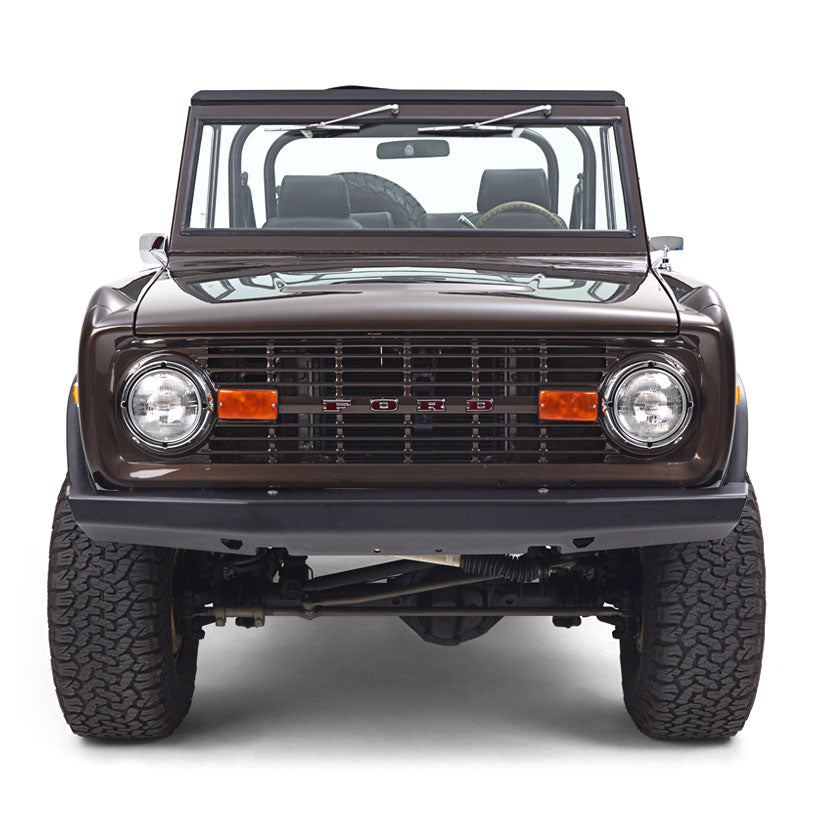 Front view of a brown Classic Ford Bronco with windshield and black interior