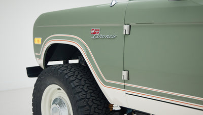 Close-up of front fender and door hinge on Classic Ford Bronco with white wheels and tires