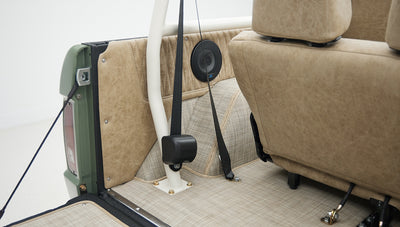 Rear interior view of Classic Ford Bronco showing seatbelt, roll bar, and speaker