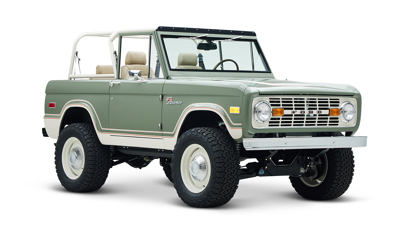 Classic Ford Bronco with rugged tires and beige seats, angled front view