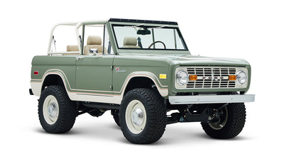 Classic Ford Bronco with rugged tires and beige seats, angled front view