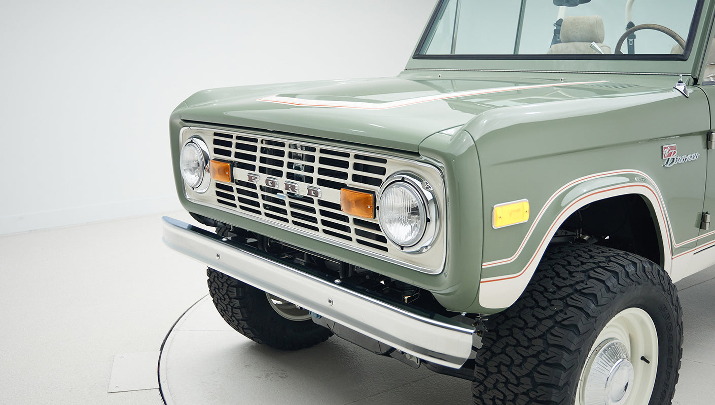 Close-up of front grille and headlight area on classic Ford Bronco in green