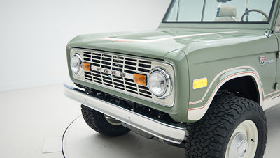 Close-up of front grille and headlight area on classic Ford Bronco in green