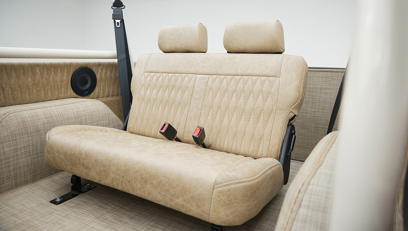 Rear bench seat covered in tan leather upholstery inside Classic Ford Bronco