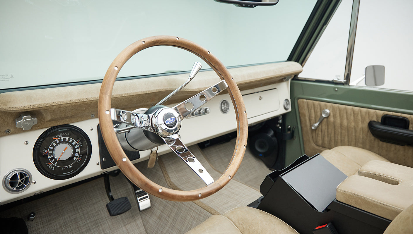 Wooden steering wheel and classic dashboard with gauges inside Classic Ford Bronco