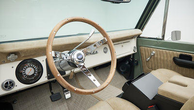 Wooden steering wheel and classic dashboard with gauges inside Classic Ford Bronco