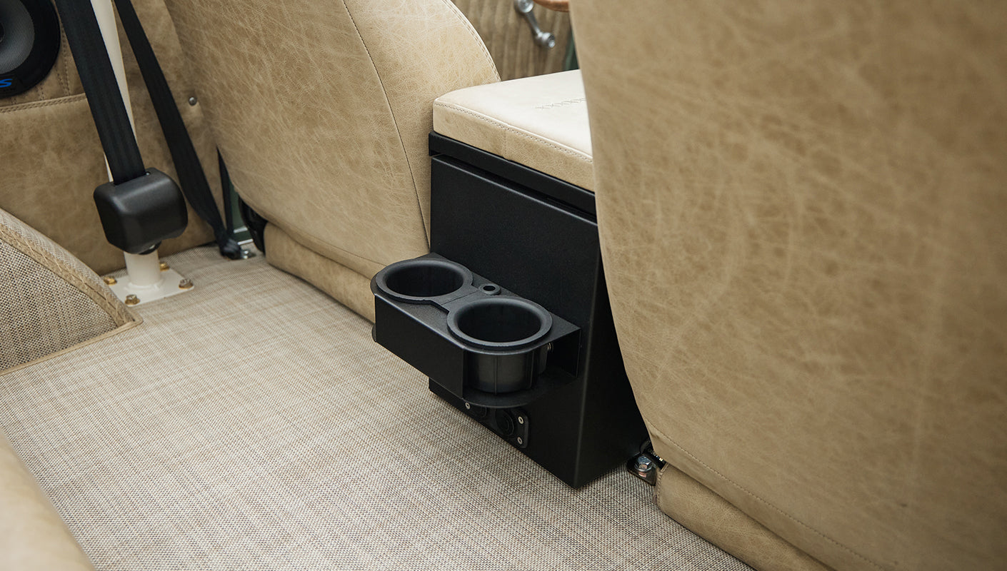 Close-up of rear seat cup holders and beige carpeted floor in Classic Ford Bronco interior
