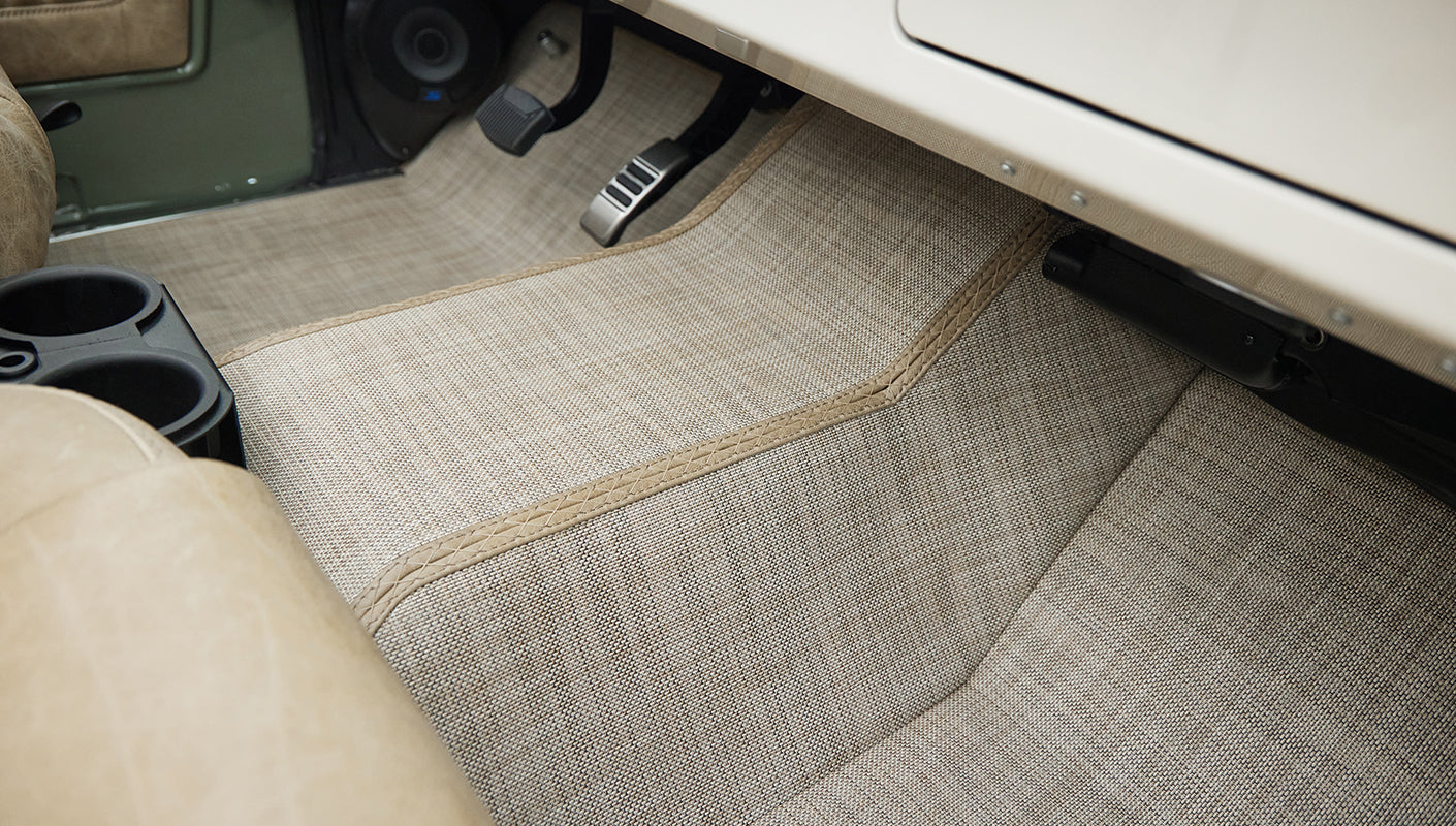 Beige textured carpet covering rear interior floor and wheel well area of Classic Ford Bronco
