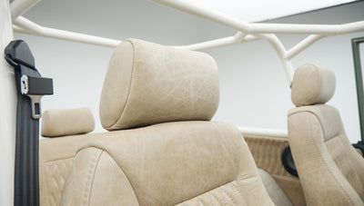 Beige leather headrests and seat backs with black seat belts inside Classic Ford Bronco